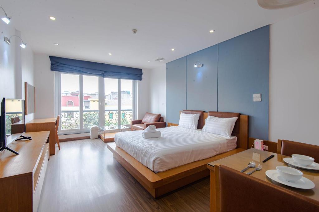 een slaapkamer met een bed, een tafel en een bank bij 22HOUSING 48 Phan Kế Bính in Hanoi