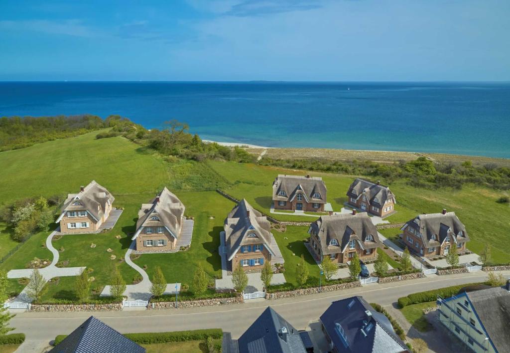 an aerial view of a house on a hill next to the ocean at Strandhaus "Oie" F661 mit Meerblick, Kamin, Sauna in Lobbe