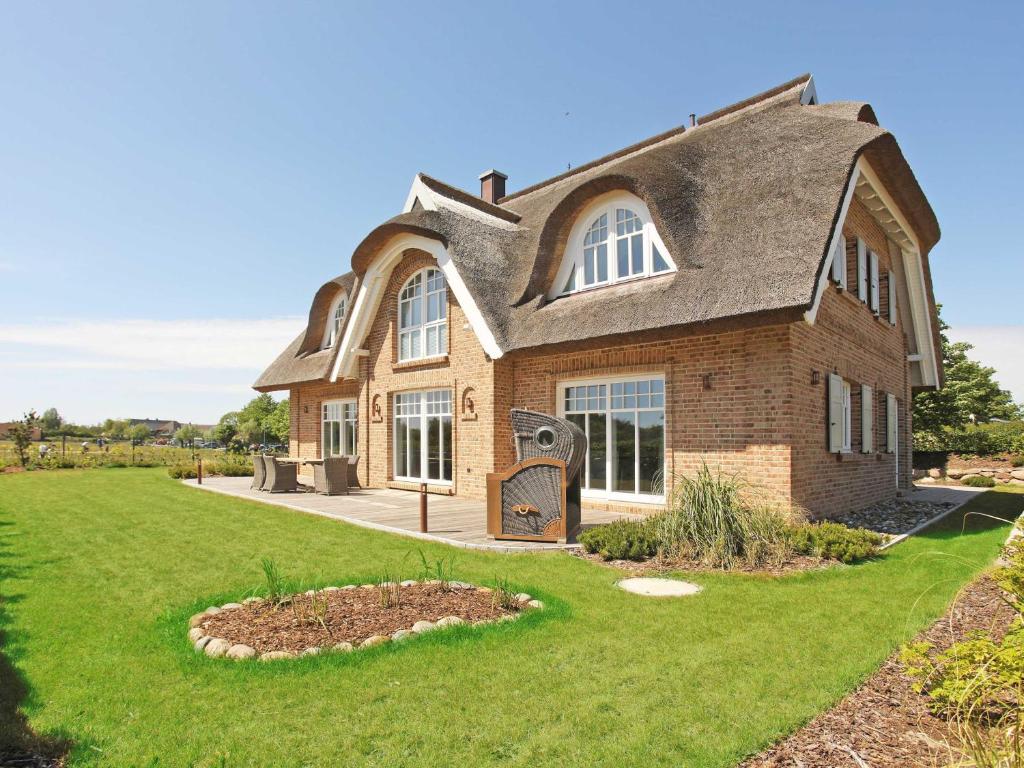 a large brick house with a gambrel roof at Strandhaus Ruden F661 Haus 5 mit Meerblick in Lobbe