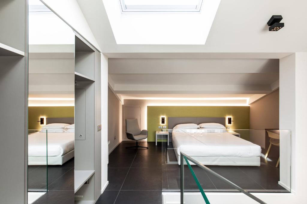 a hotel room with two beds and a desk at RB del Teatro&Apartaments in Imola