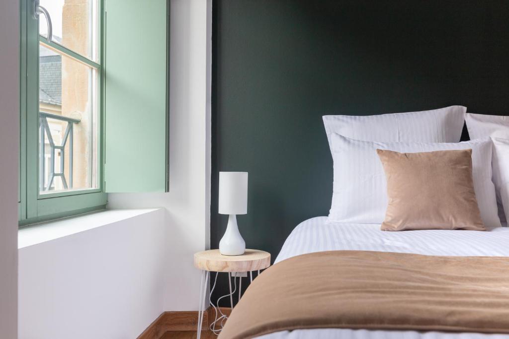 een slaapkamer met een bed met een groene accentmuur bij My Colmar Homes - Le XIII in Colmar