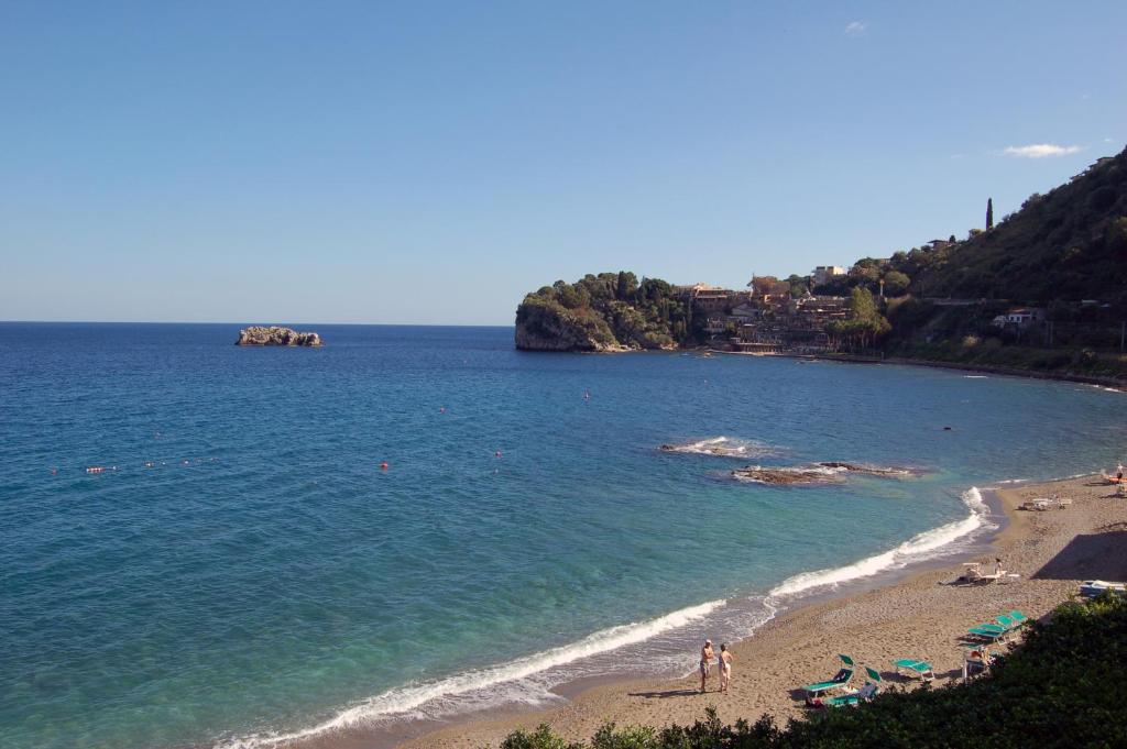a beach with people on the sand and the water at Hotel Lido Mediterranee in Taormina