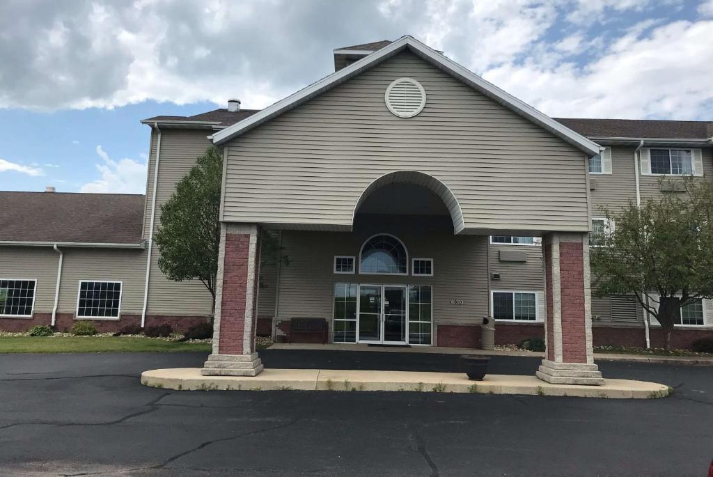 una casa con una ventana arqueada en una calle en AmericInn by Wyndham Maquoketa, en Maquoketa