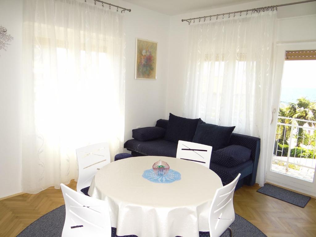 salon z białym stołem i krzesłami w obiekcie Apartment Marohnić w mieście Malinska