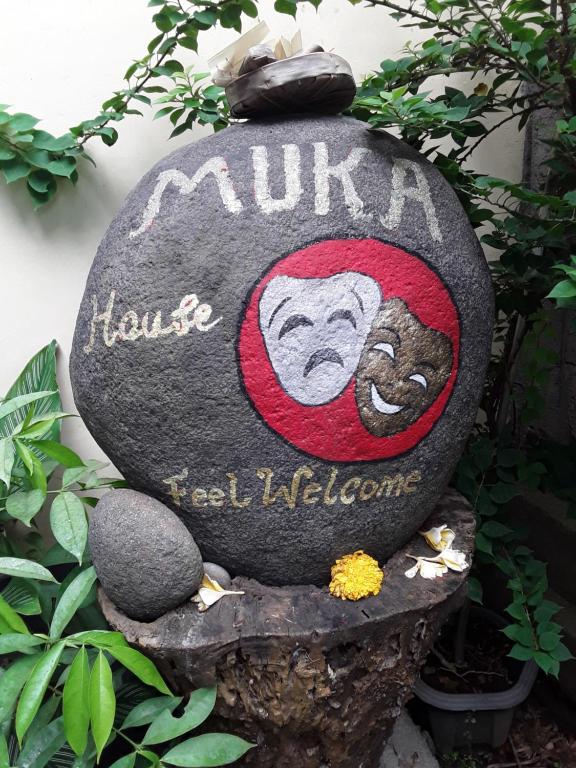 a rock with a monkey painted on it at Muka House in Ubud