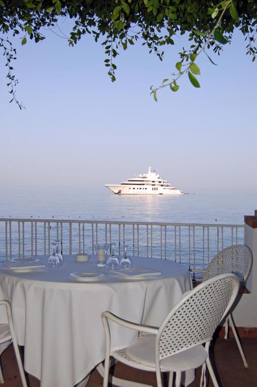 a table with a cruise ship in the water at Hotel Lido Mediterranee in Taormina