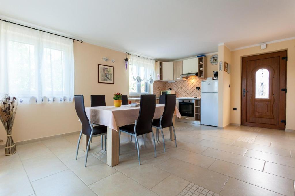 une cuisine et une salle à manger avec une table et des chaises dans l'établissement Apartments Dario, à Porat