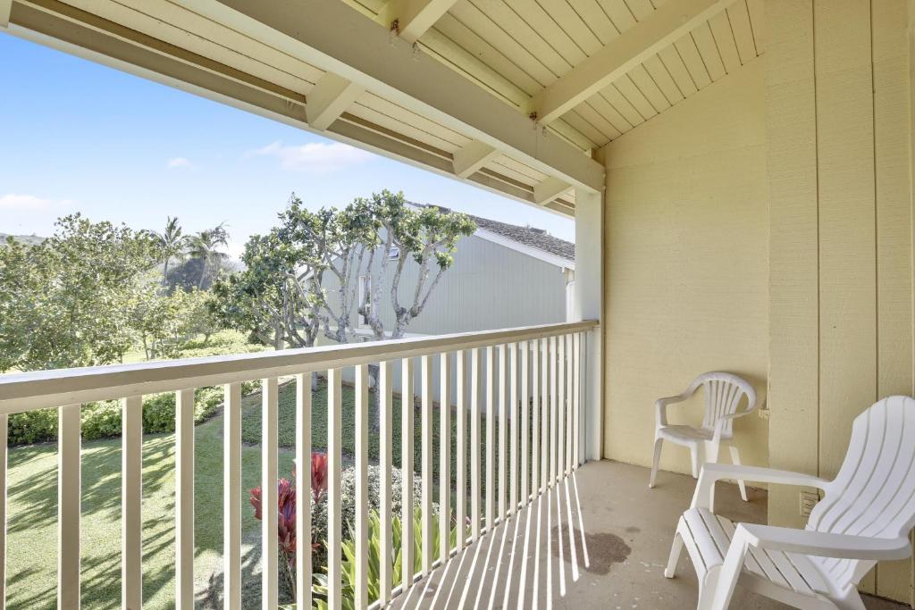 a balcony with two white chairs and a dog on it at Turtle Bay Sea BreezeNUC 90-TVU-0498 in Kahuku