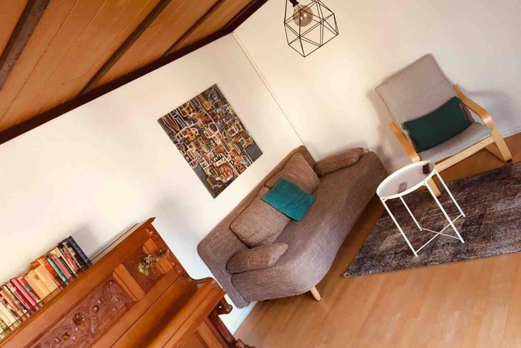 uma sala de estar com um sofá e uma cadeira em Haus im Garten „zentral und doch sehr ruhig“ em Elten
