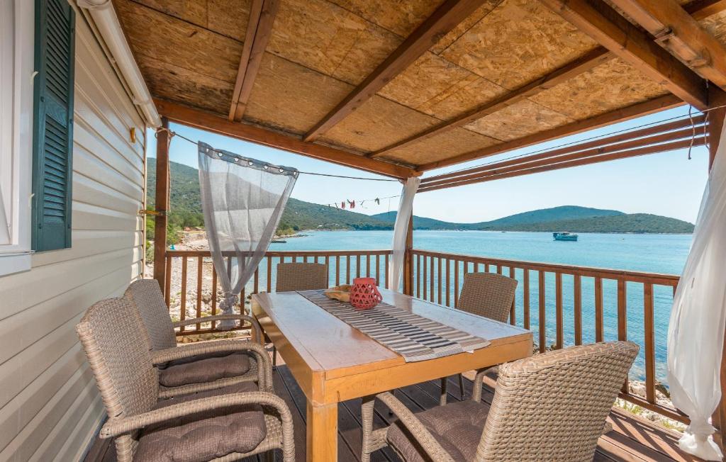 einen Tisch und Stühle auf einem Balkon mit Blick auf das Wasser in der Unterkunft Seascape bungalow with terrace with seaview in Mali Pašman