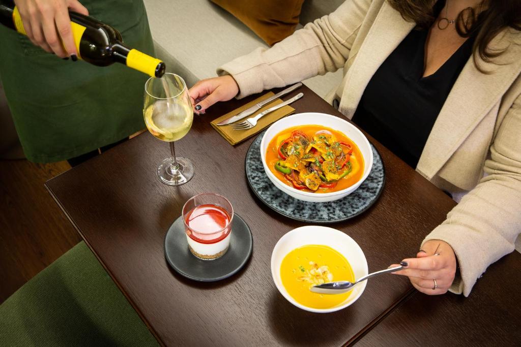 a woman is sitting at a table with a bowl of food at Gallery Hostel in Porto