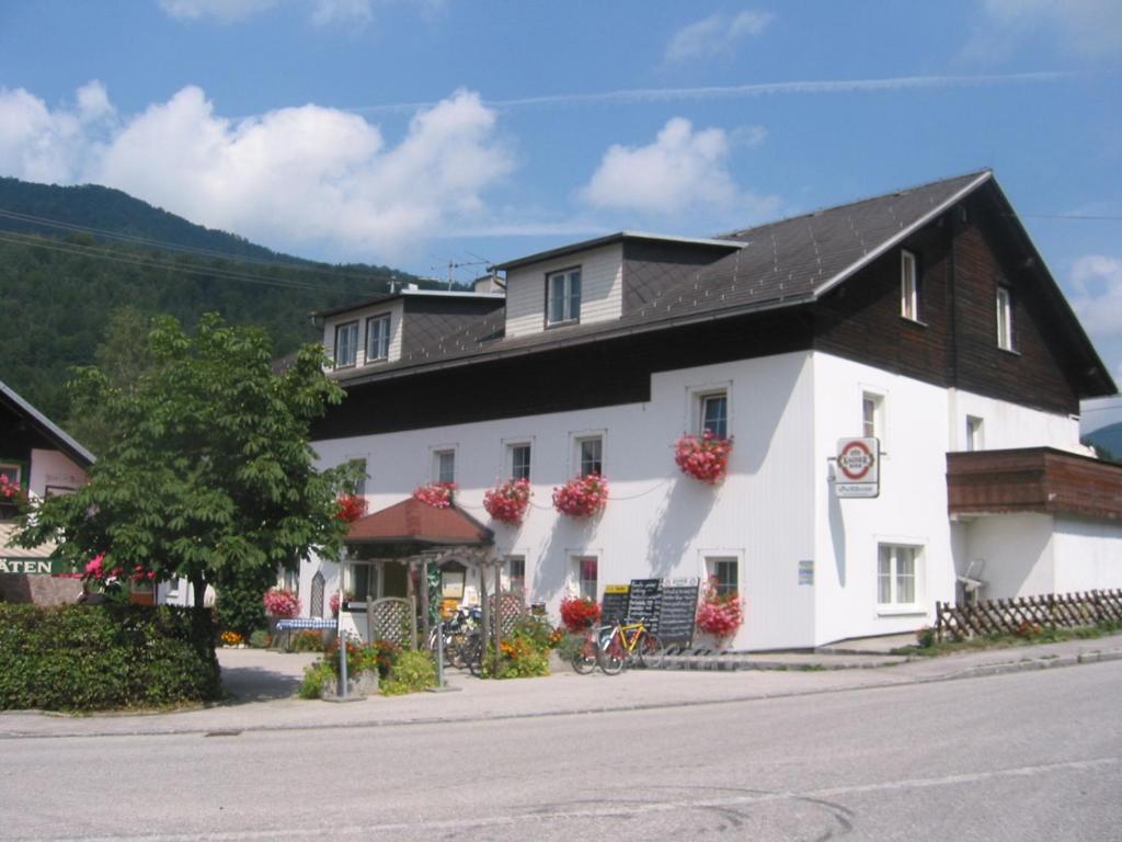 ein weißes Gebäude mit schwarzem Dach in der Unterkunft Gästehaus Dürnberger in Molln