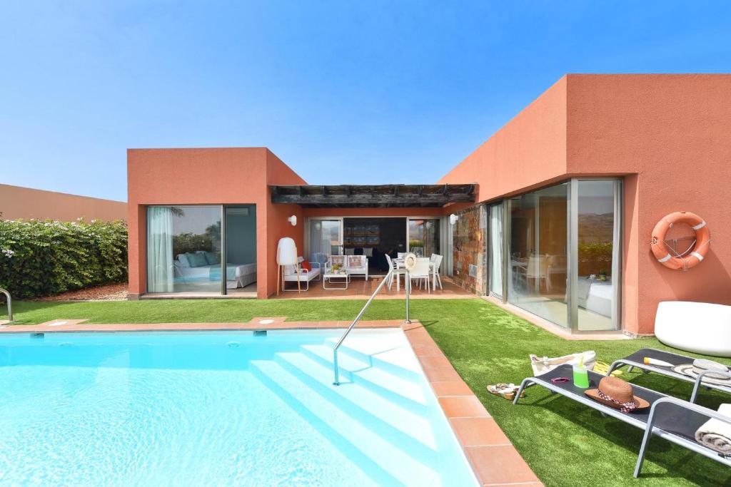 a villa with a swimming pool and a house at Albatross by VillaGranCanaria in Maspalomas