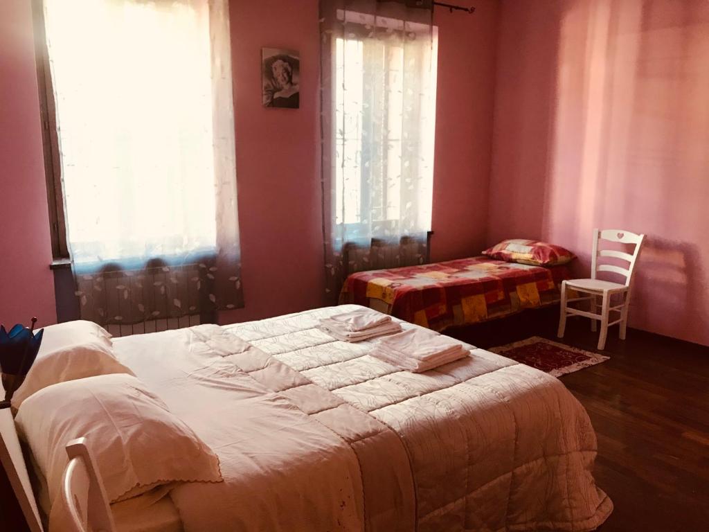 1 Schlafzimmer mit 2 Betten und 2 Stühlen in der Unterkunft Appartamento Francesca in Cislago