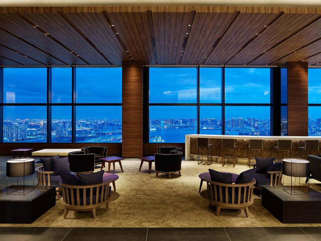 - un hall avec des chaises, des tables et de grandes fenêtres dans l'établissement Mitsui Garden Hotel Toyosu Premier - Tokyo, à Tokyo