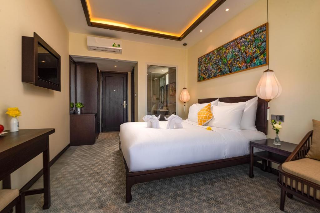 Postel nebo postele na pokoji v ubytování Hoi An Merrily De Art Hotel