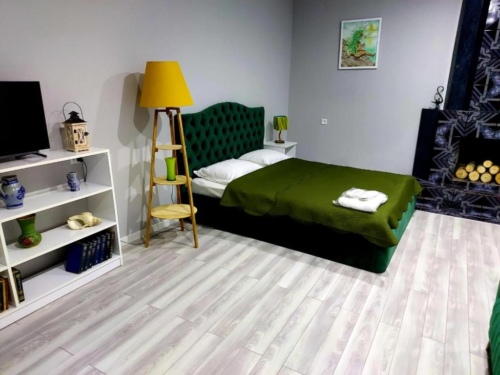 una camera con letto verde e televisore di Ardoni Hotel a Tbilisi City