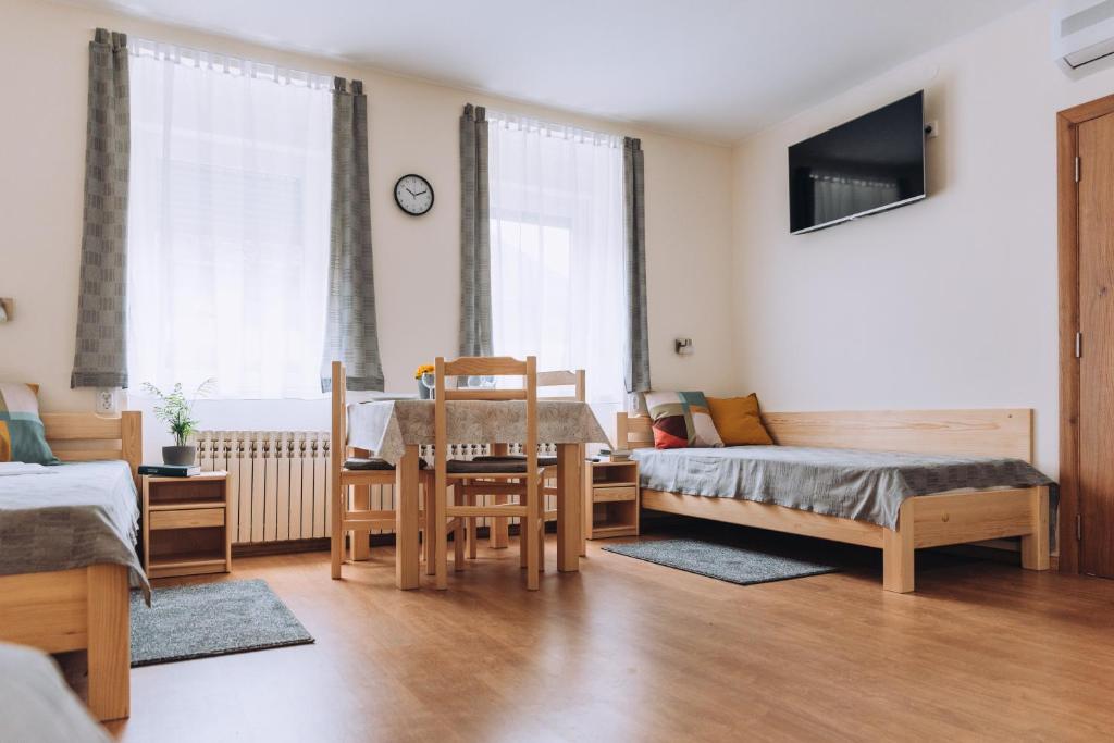 a living room with a table and chairs and a bed at Apartman Ady 6 in Senta