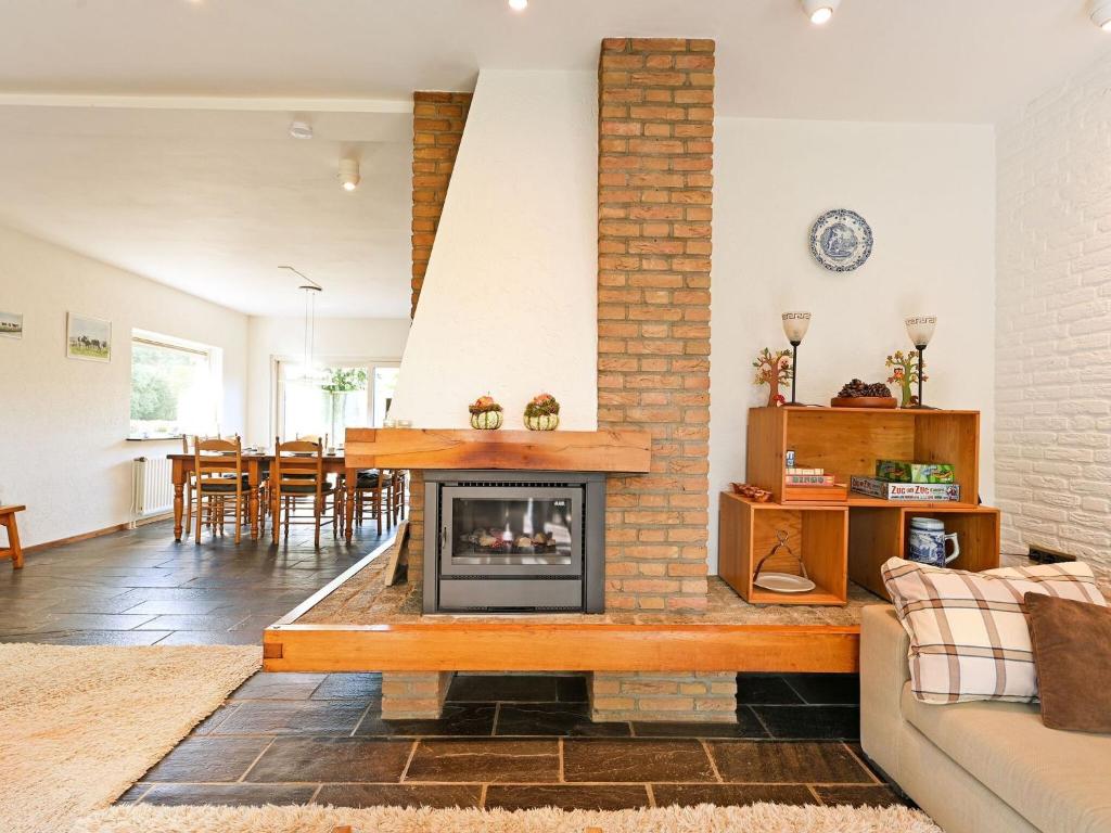 a living room with a fireplace and a table at Luxury Holiday Home with Terrace in Beek