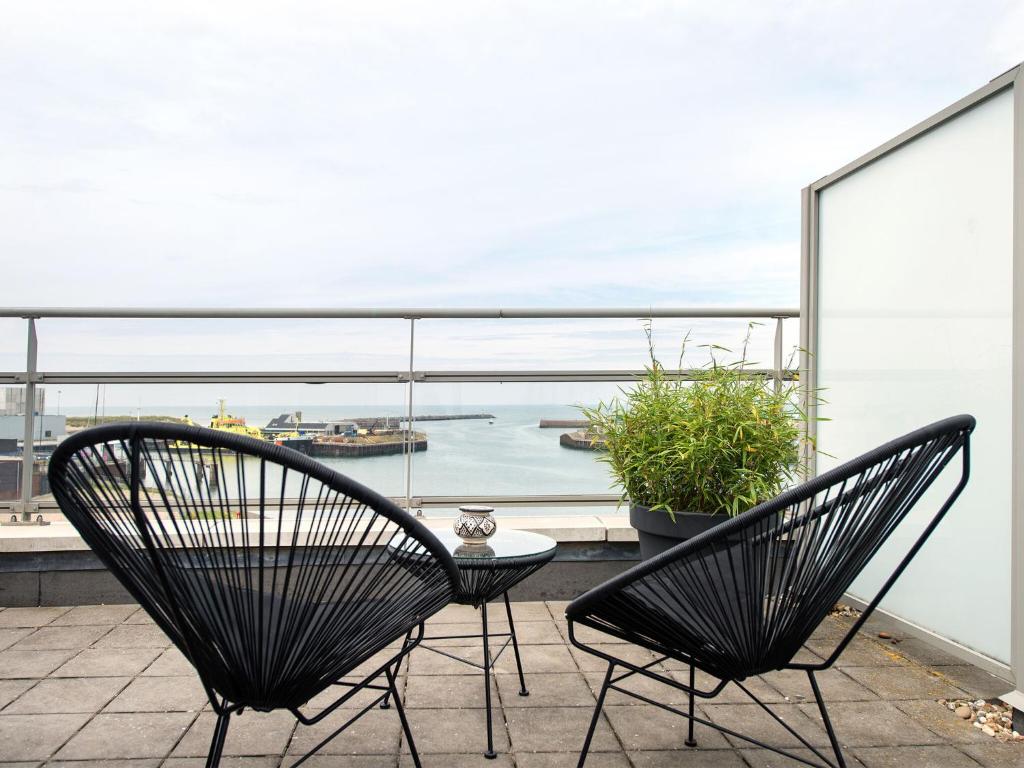 two chairs sitting on a balcony with a view of the ocean at Sea view apartment in Den Haag with terrace in Scheveningen