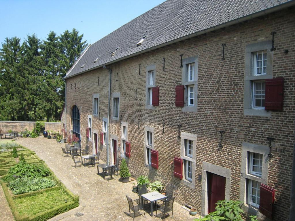 - un bâtiment en briques avec des portes rouges et une cour dans l'établissement Welcoming Apartment near Town Center in Mesch, à Mesch