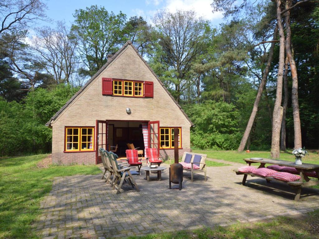 una pequeña casa con una mesa y sillas frente a ella en Detached holiday home surrounded by nature, en Zuidwolde