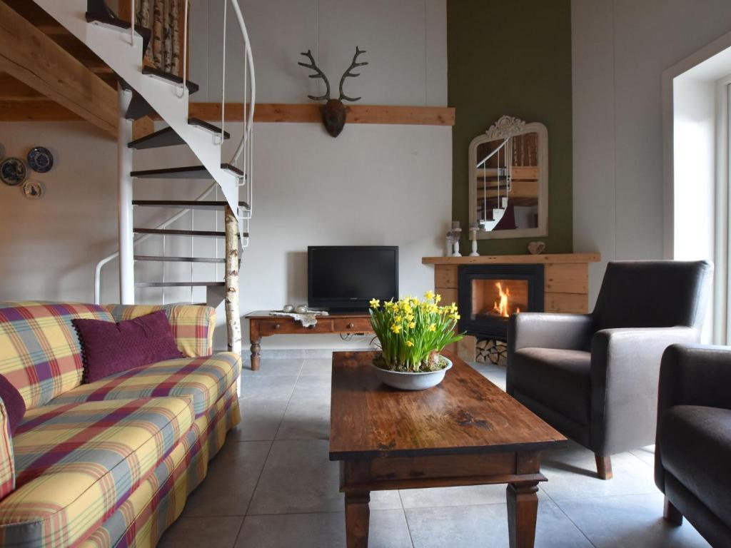 a living room with a couch and a table and a fireplace at Lovely Holiday Home in Nistelrode near Lake in Nistelrode