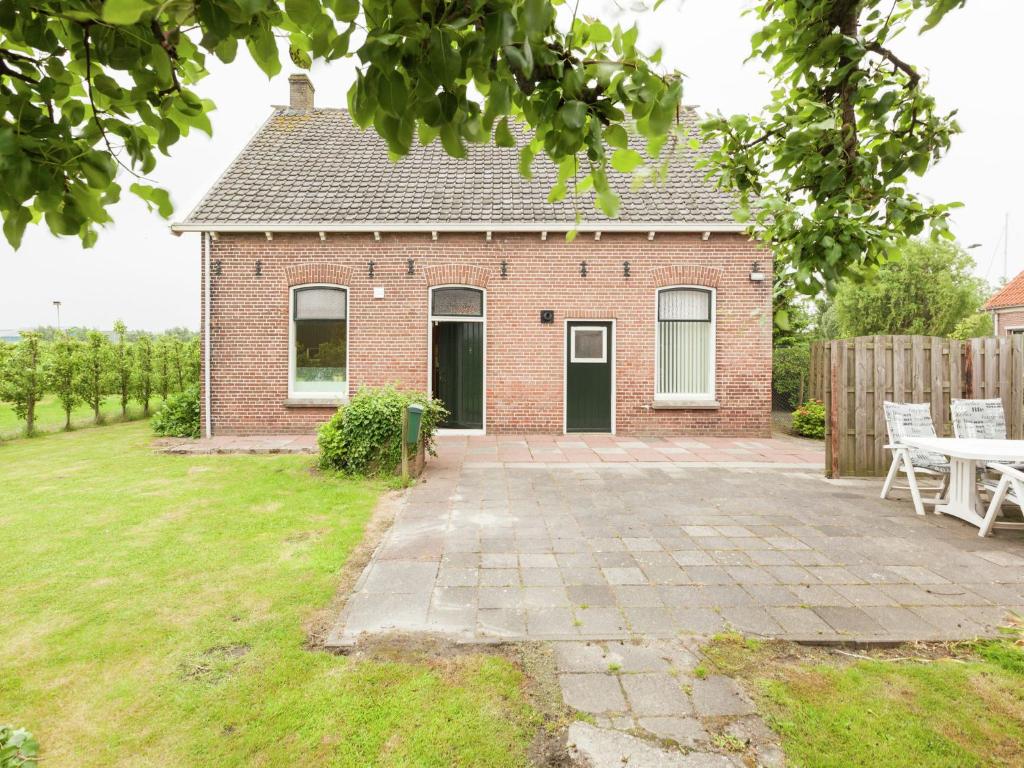 ウェーメルディンゲにあるLovely Cottage near Sea in Wemeldingeのレンガ造りの家で、正面にパティオがあります。