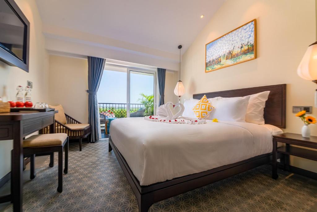Postel nebo postele na pokoji v ubytování Hoi An Merrily De Art Hotel