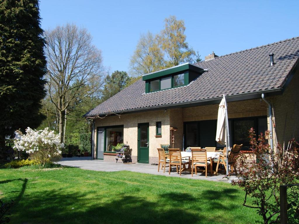 VenhorstにあるStunning villa in Venhorst with saunaのパティオ(テーブル、椅子付)が備わる家です。