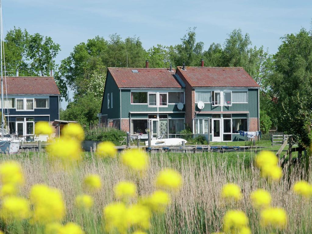 two houses in a field with yellow flowers in the foreground at Delightful Holiday Home in Warns with Jetty in Warns