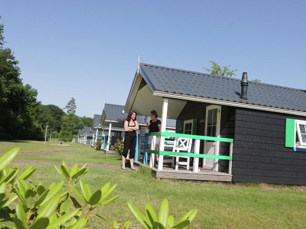 IJhorstにあるCozy chalet with a dishwasher, in a holiday park in a natural environmentの家の玄関に立つ二人