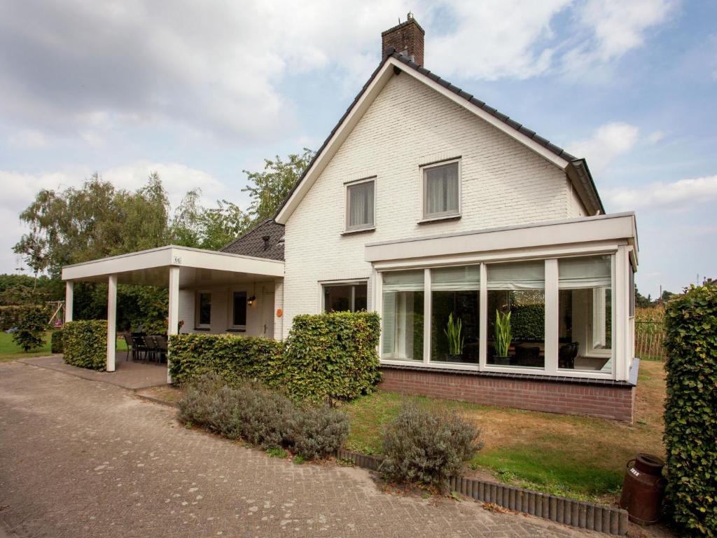 een wit huis met grote ramen bij Majestic, large holiday home near Leende, detached and located between meadows and forests in Leende