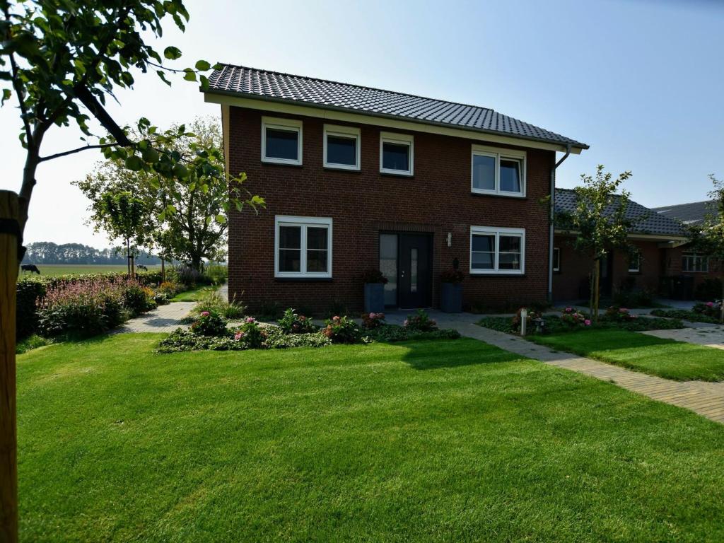 a brick house with a green lawn at Luxury Villa in Megchelen with Sauna in Megchelen