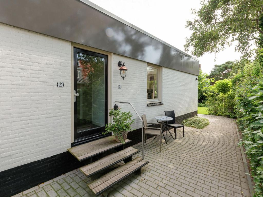 a house with a patio with a table and chairs at Apartment in Bergen near Schoorl Dunes in Bergen