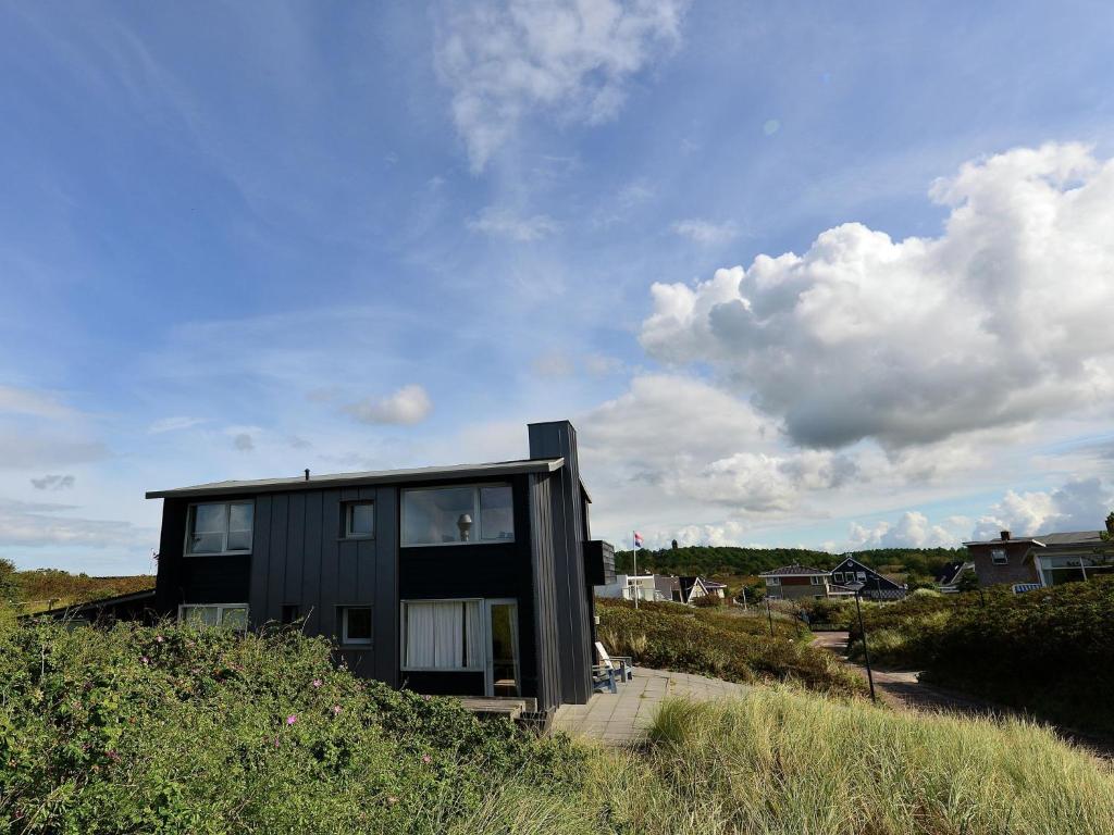 ベルゲン・アーン・ゼーにあるUnique holiday home in Bergen aan Zee with terraceの丘の上に座る黒家