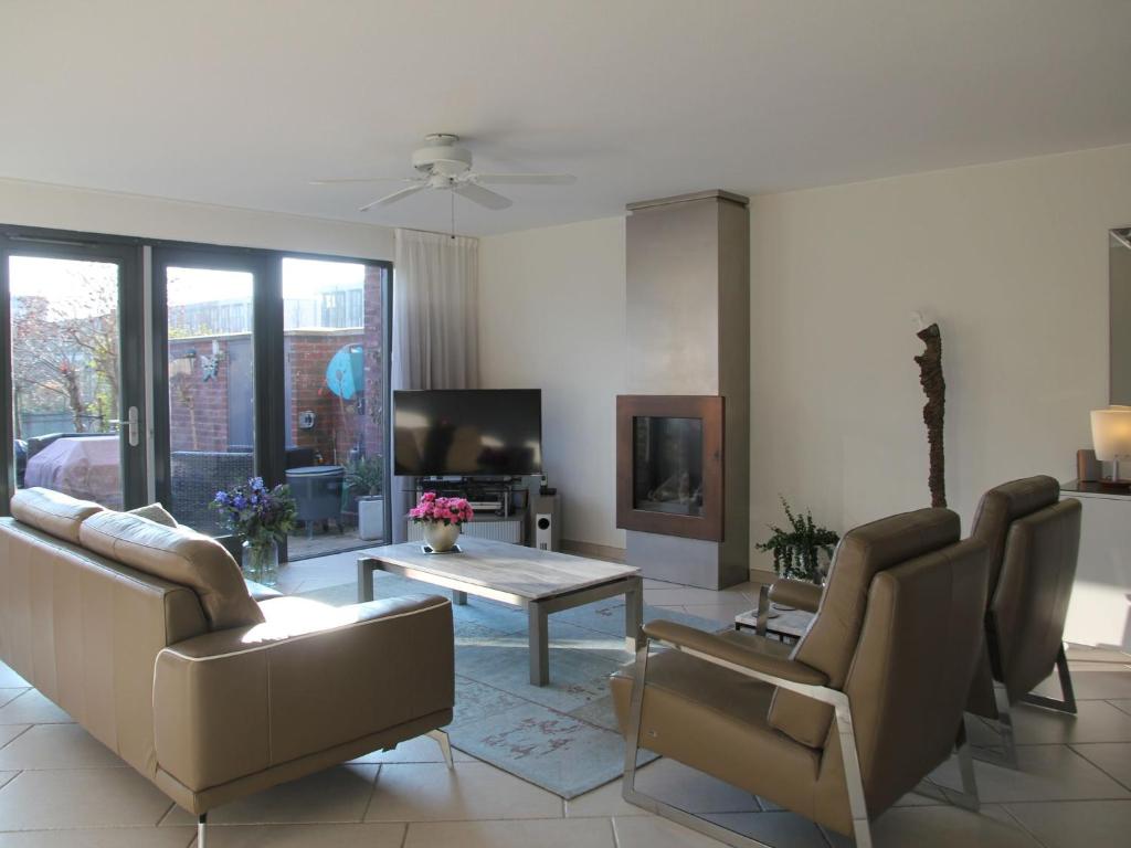 a living room with couches and a table and a tv at Sunny holiday home in Alkmaar on the water in Alkmaar