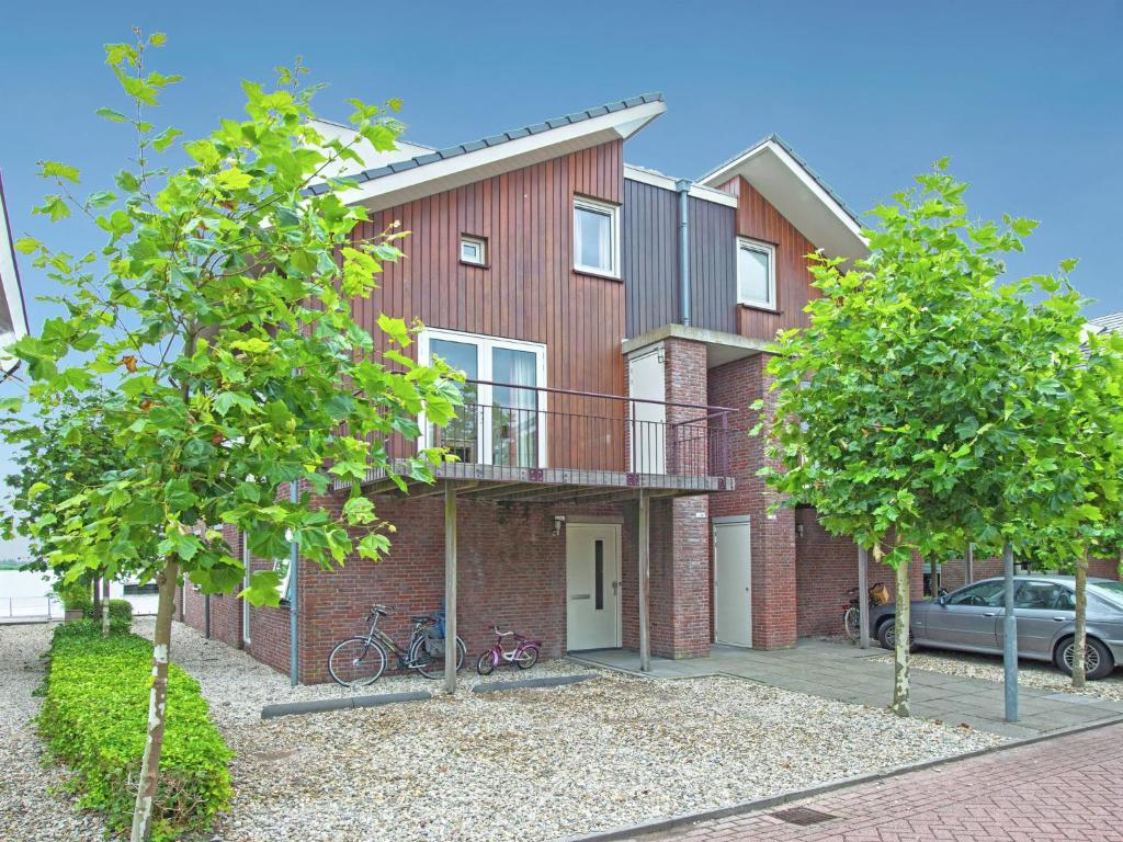 Cette maison en briques rouges dispose d'un balcon et d'une voiture. dans l'établissement Tidy apartment with dishwasher close to Amsterdam, à Uitgeest