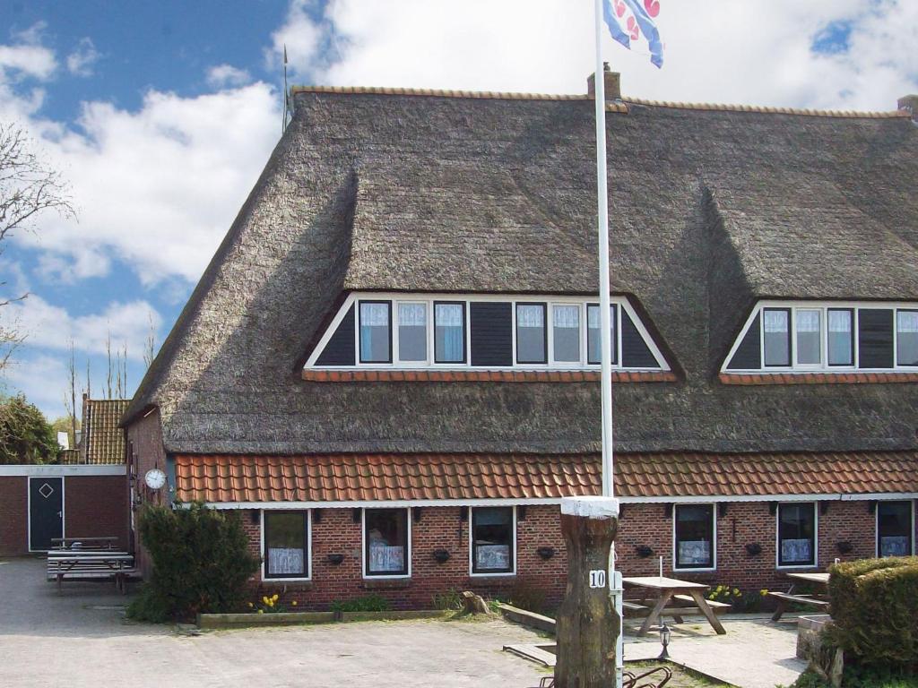 ホルウェルトにあるAuthentic holiday home in North Frieslandの旗の建つ建物