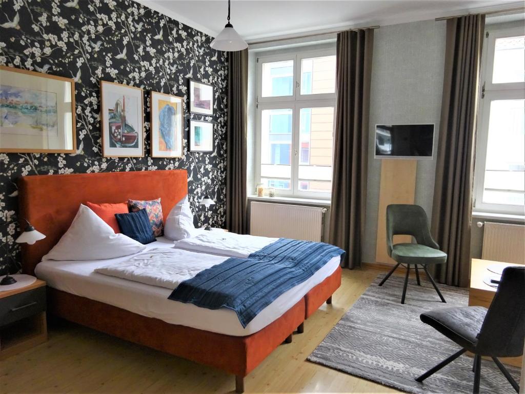 a bedroom with a bed and a desk and a chair at Pension Zur Fährbrücke in Stralsund