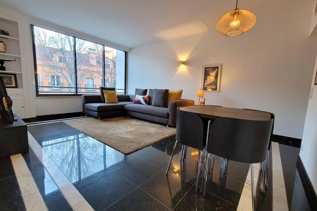 a living room with a couch and a table at Marble Home - São Sebastião in Lisbon