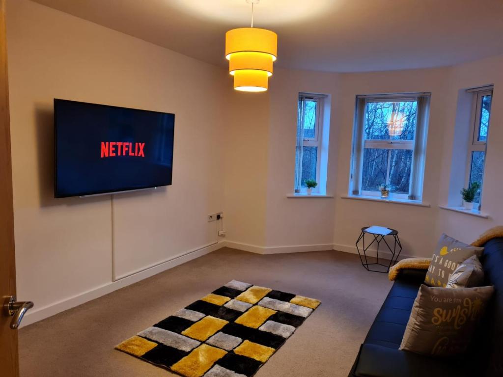 uma sala de estar com uma televisão de ecrã plano na parede em Patton Place, Warrington, 1 Bedroom, Safari Themed, High Speed WiFi, Smart TV, Amazing Train Links, Secure Location, Hotel Vibe in a Home em Great Sankey