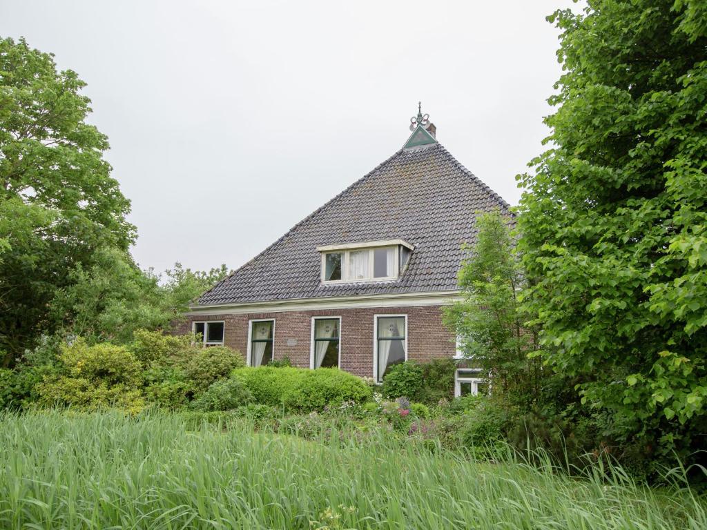 une maison avec un toit en gambrel et un jardin dans l'établissement Modern Farmhouse in Molkwerum near the Lake, à Molkwerum