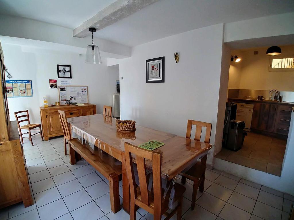 cocina y comedor con mesa de madera y sillas en Gîte Pilpoil, en Sault-de-Vaucluse