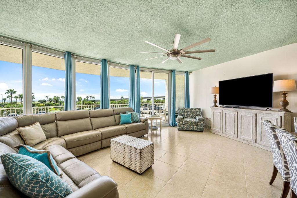 uma sala de estar com um sofá e uma televisão de ecrã plano em Newly Updated Caribe 213B em Orange Beach