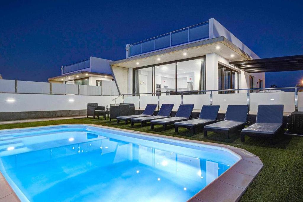 una piscina di fronte a una casa di notte di Seven Dreams Villas a Corralejo