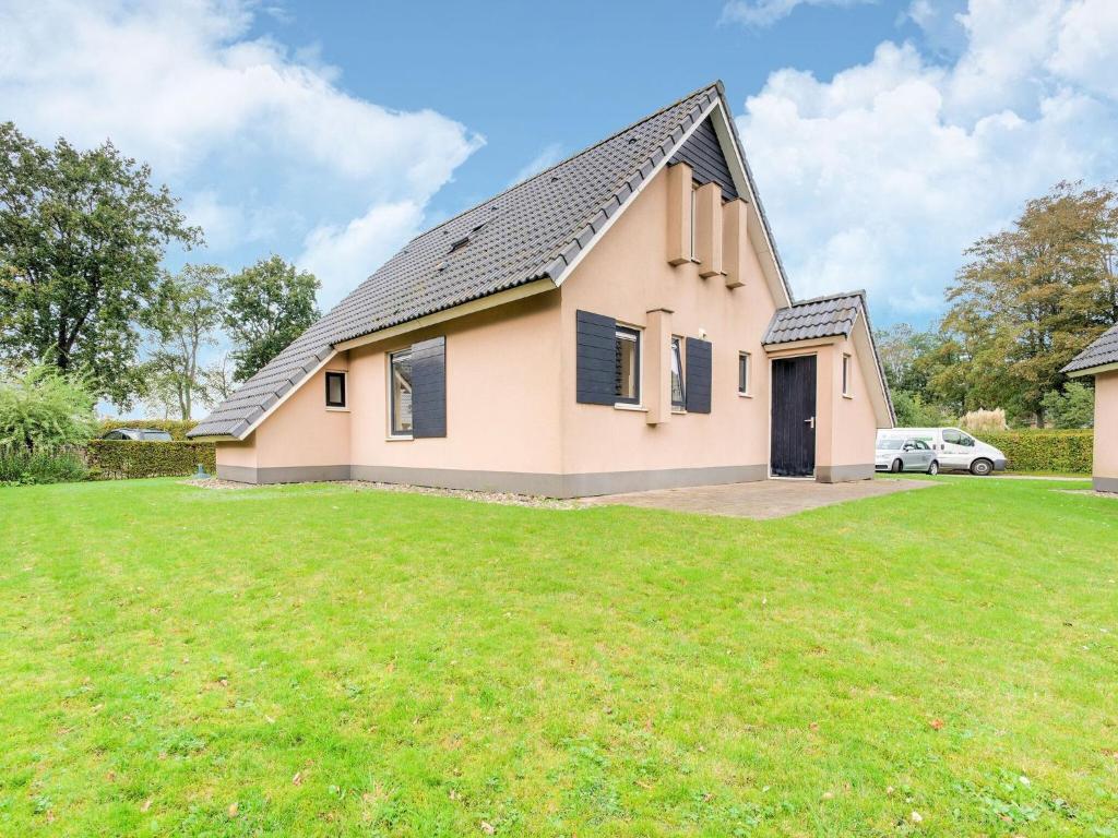 una casa con un césped verde delante de ella en Serene Holiday Home in Gaasterl n Sleat, en Sondel