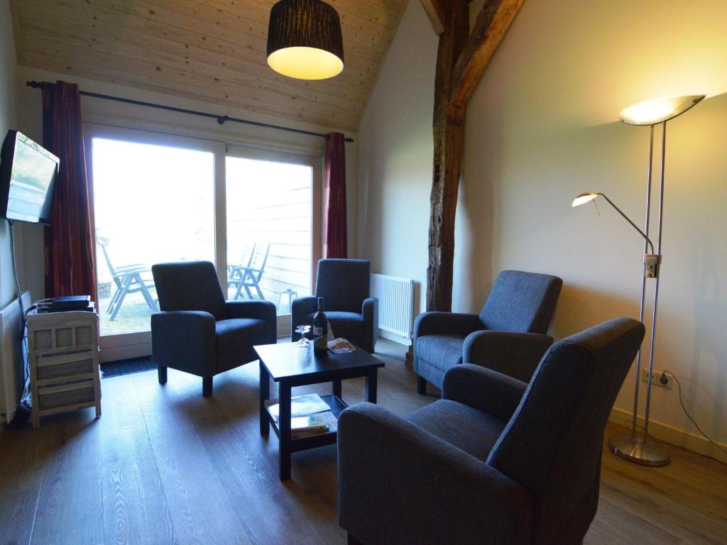 a living room with chairs and a table and a television at Pet-Friendly Getaway in Geesteren