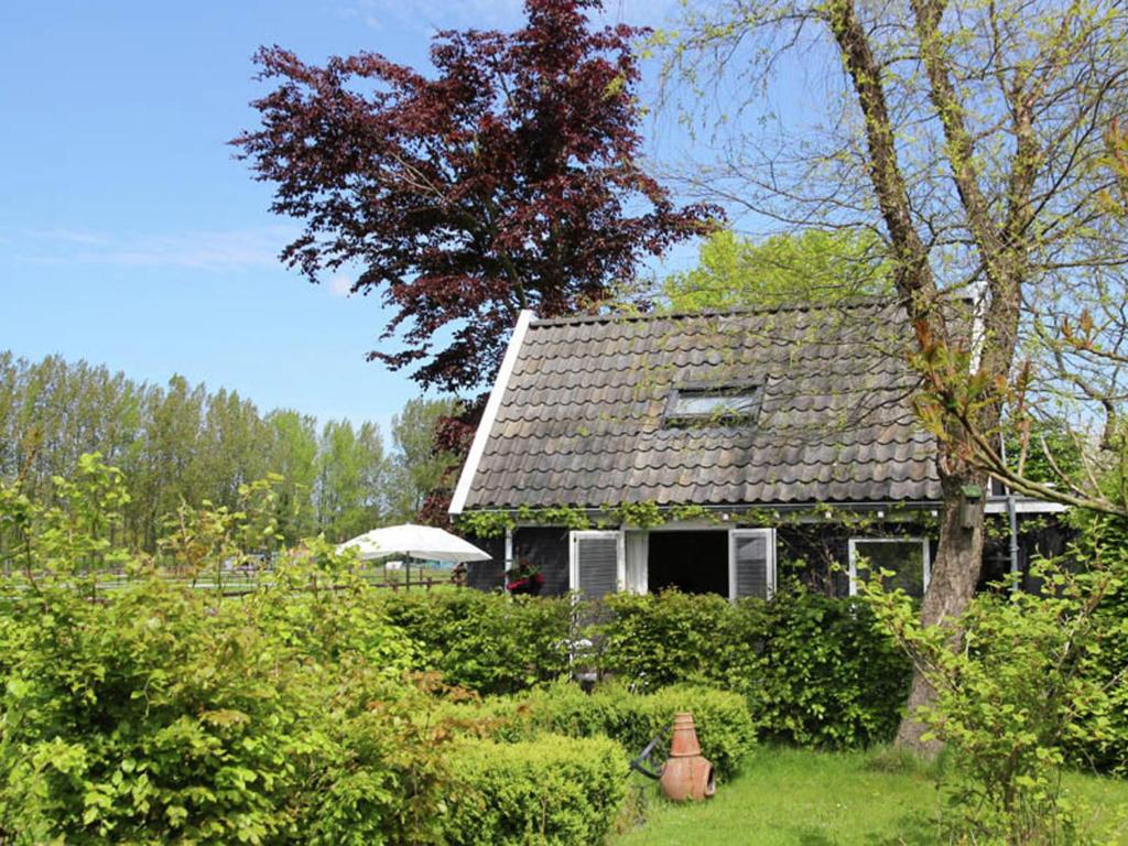 a house with a roof in a yard at Holiday home for two people at a peaceful central location in Heiloo near Egmond in Heiloo