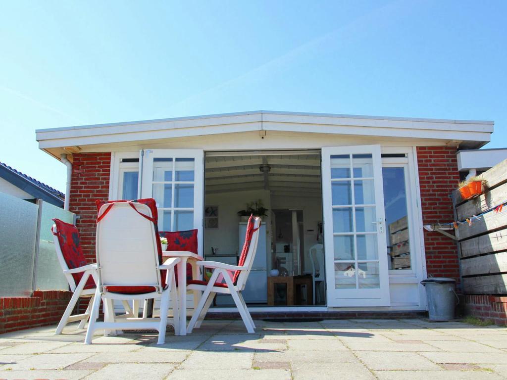 un grupo de sillas y una mesa en un patio en Cosy vacation home near the beach, en Egmond aan Zee